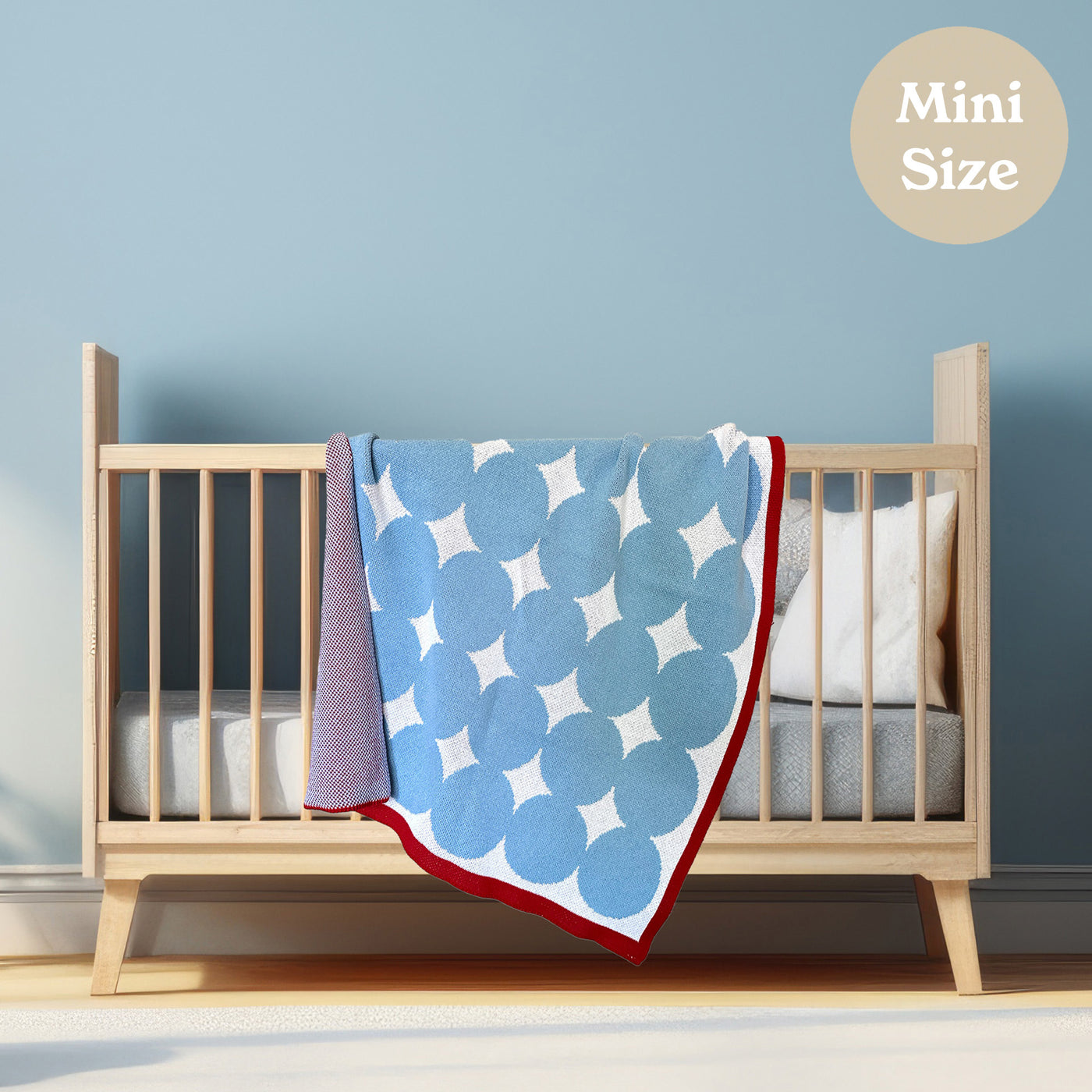 Light Blue and Red Baby Blanket on Cool Light Wood Crib