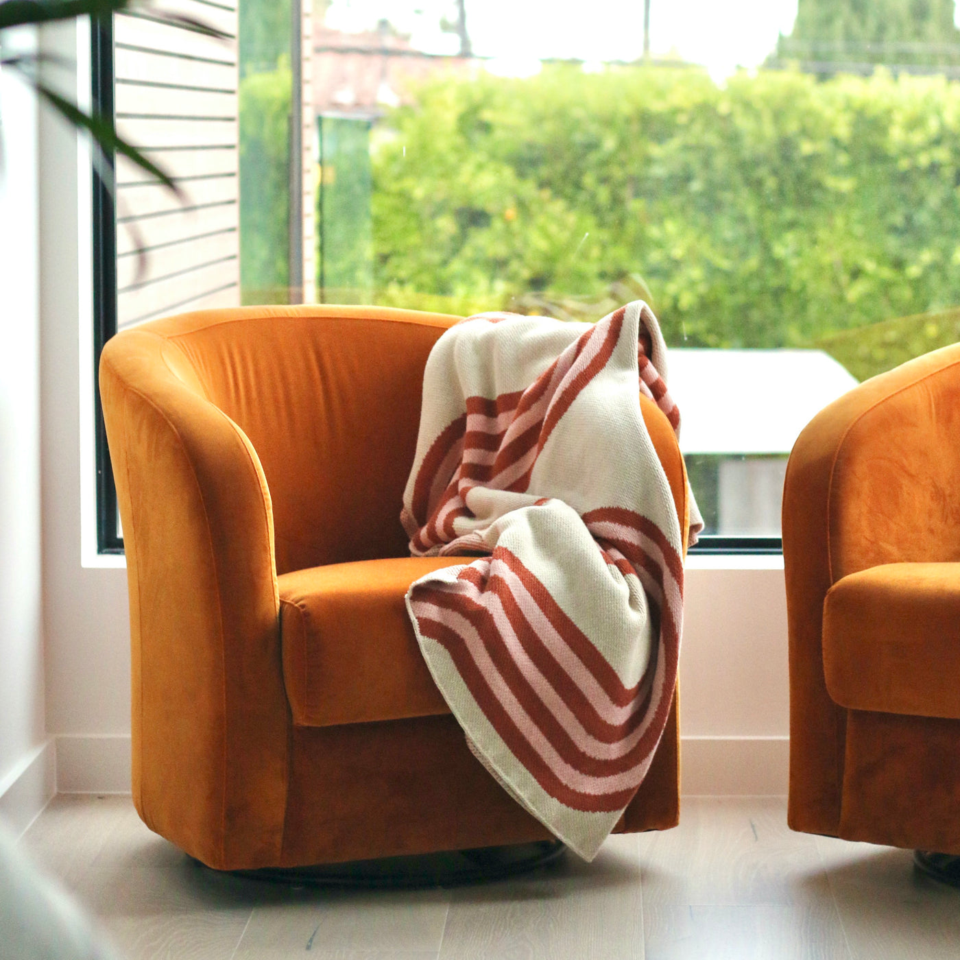 Orange Velvet Chair with Beige and Pink Throw Blanket 