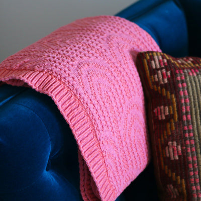 Bright Pink Throw on a Blue Velvet Sofa