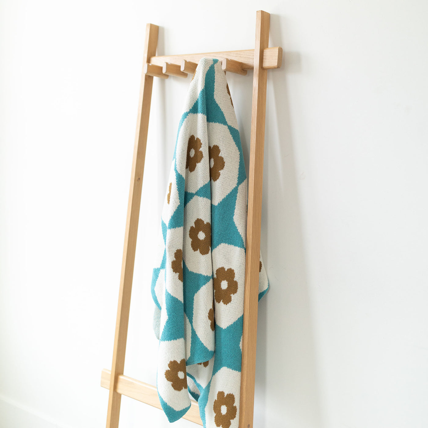Turquoise and Gold Bold Pattern Throw on Coatrack