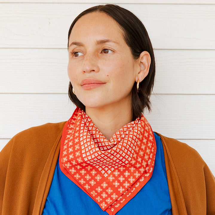 Woman wearing a red patterned scarf with a white background