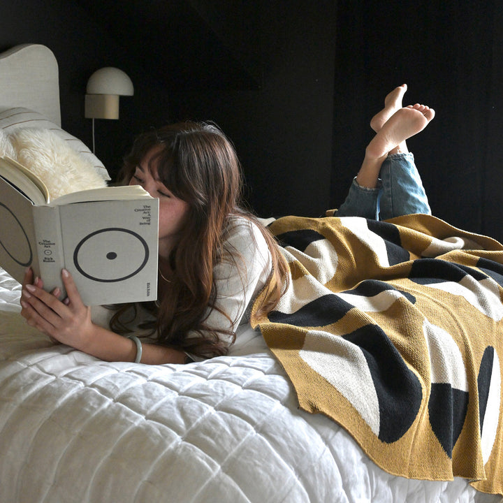 The Creative Act Book and Woman Reading with a Cirlcle Pattern Throw Blanket