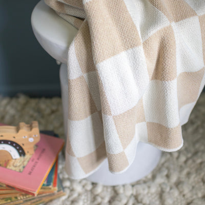 Tan checkered blanket in cozy nursery
