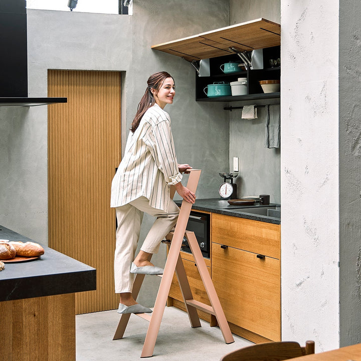 Woman using a step stool in a modern kitchen