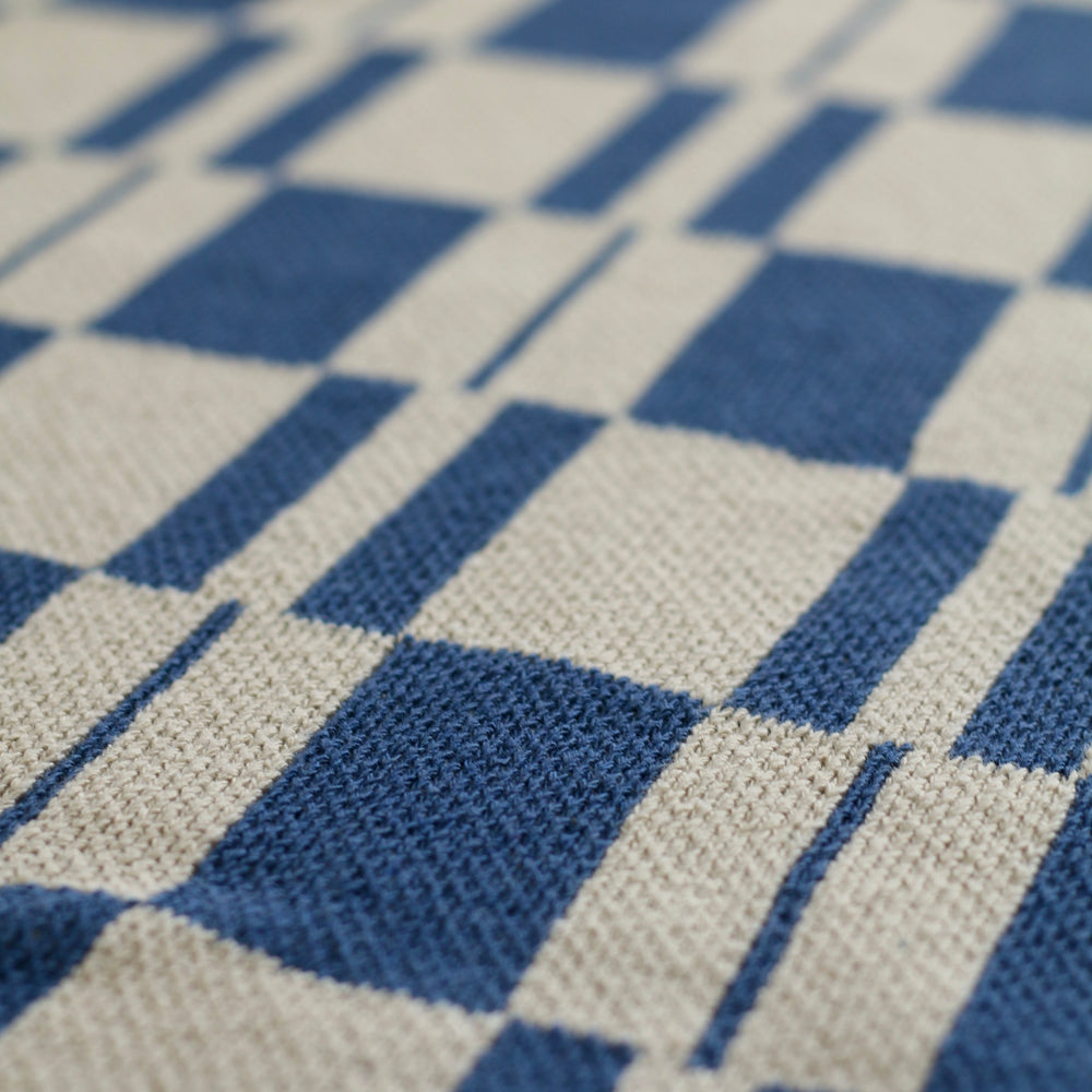 close up of blue and beige rectangle pattern throw blanket