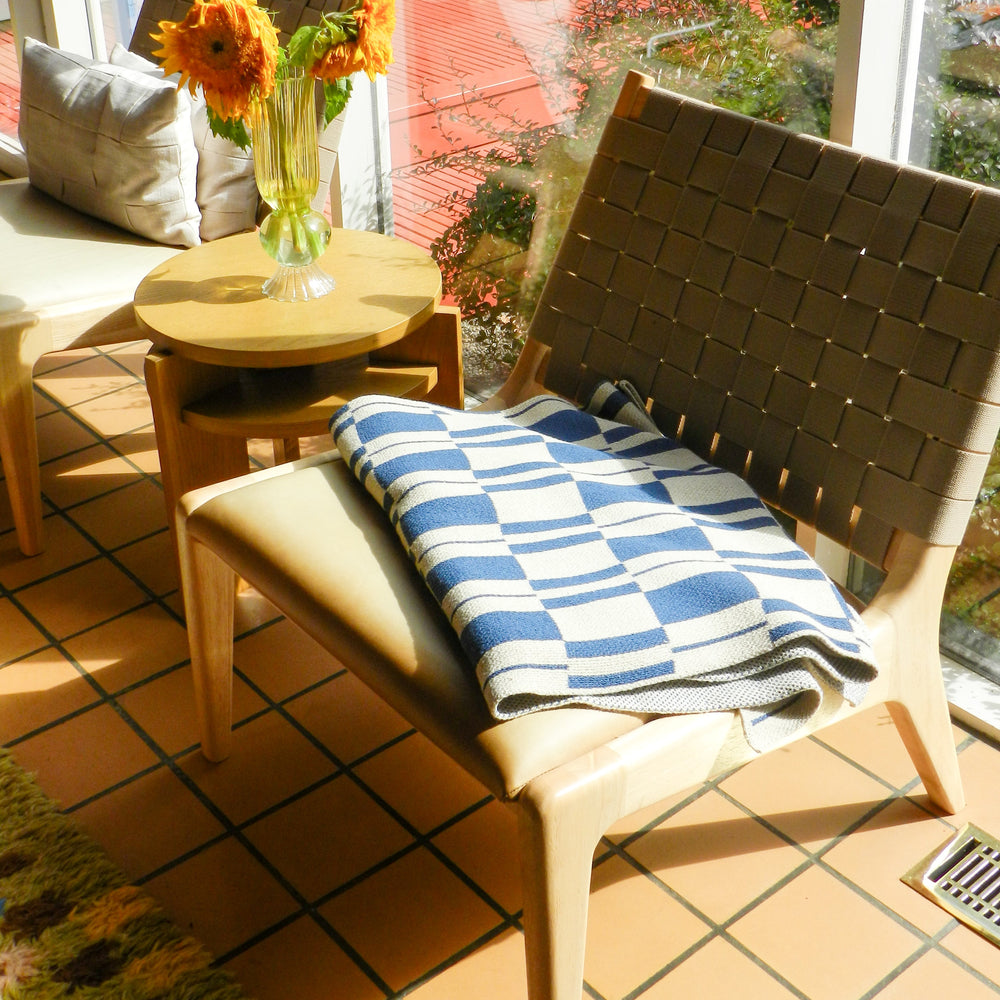 Blue Modern Geometric Throw Blanket in on a sunny window chair