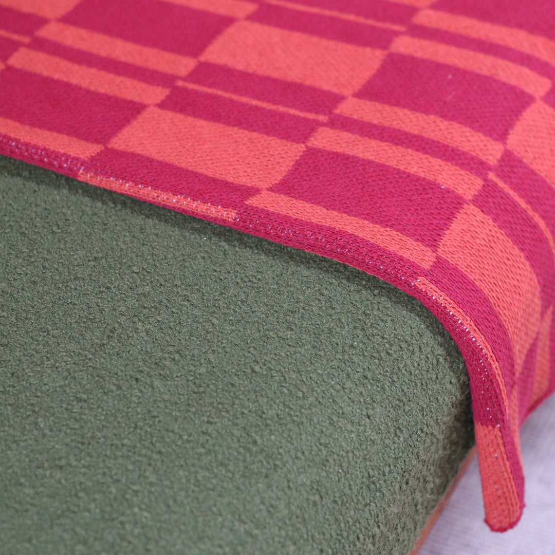 Close-up of an orange and red checkered  throw blanket