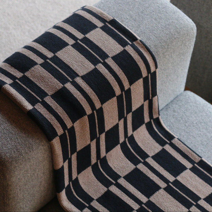 Modern Check Throw in Taupe and Black on a Grey Chair
