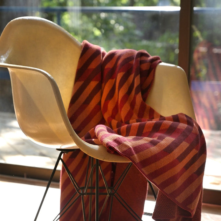 red diagonal stripe throw on a fiberglass eames chair