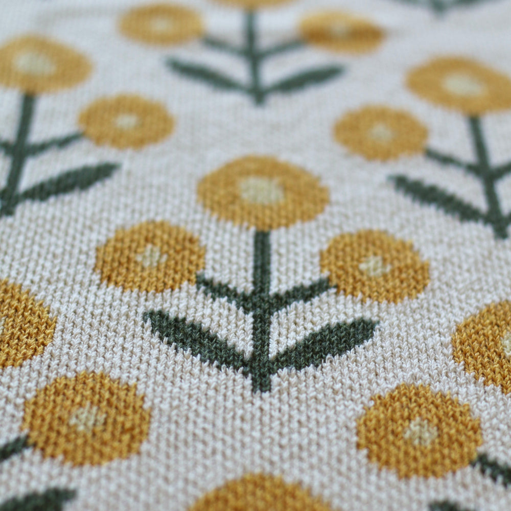 Close-up of throw blanket with yellow floral pattern