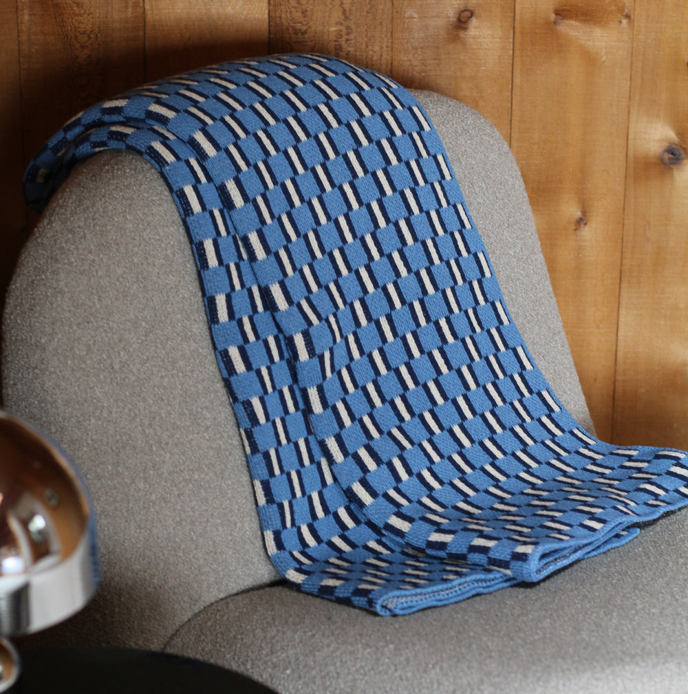 Blue knit throw on a beige chair