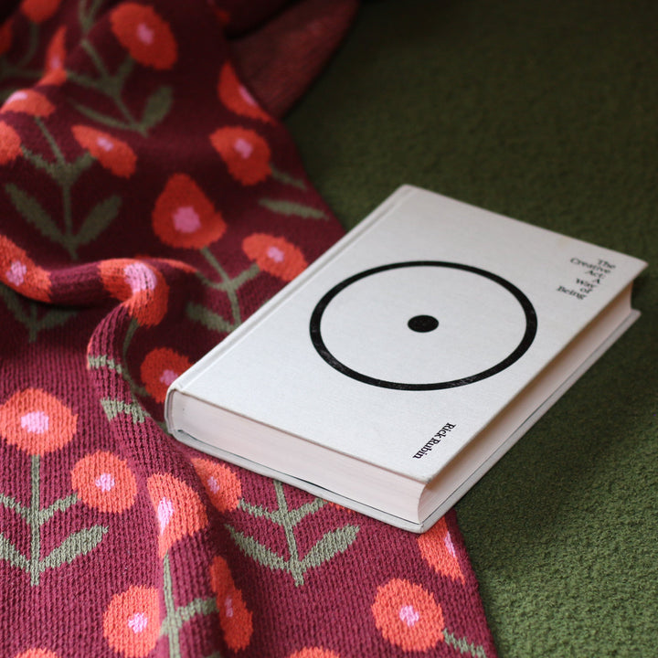 Small book with a circular design on a floral throw blanket background