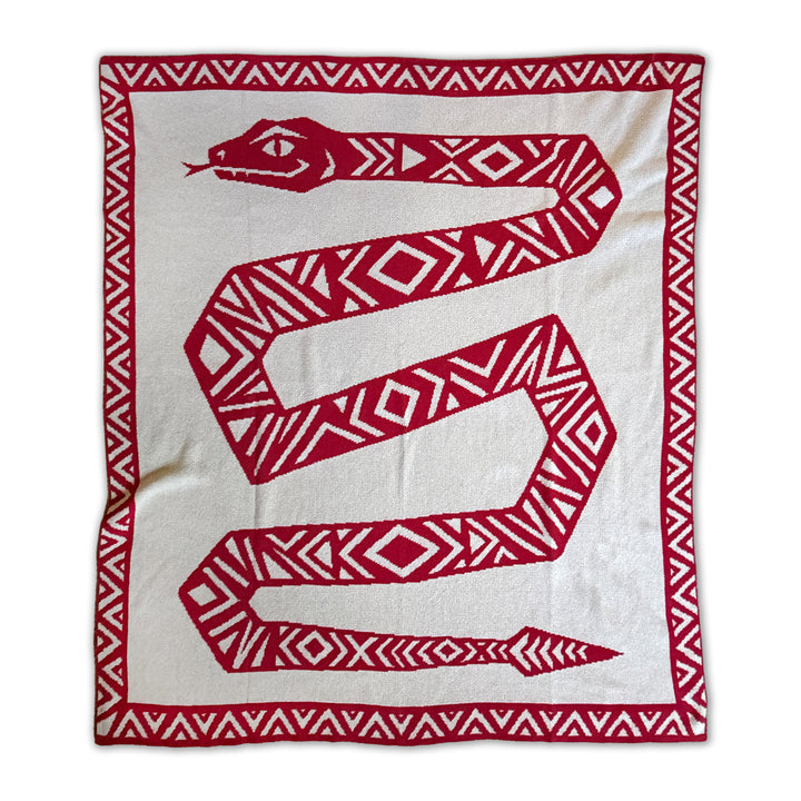 A knitted throw blanket featuring a large red snake with geometric patterns on a beige background, bordered by a red and beige patterned edge.