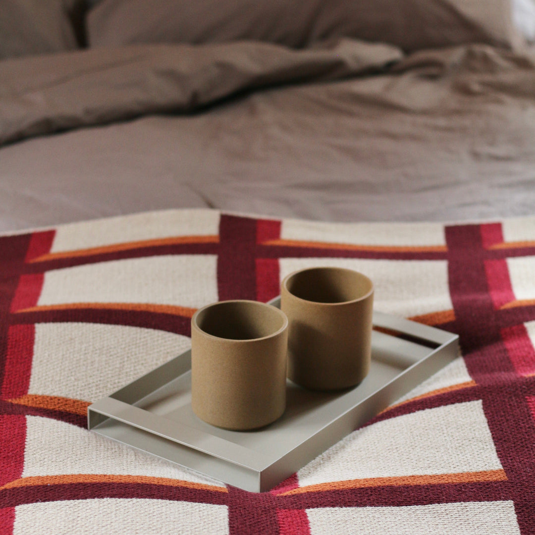 Modern Grid Throw Blanket in Burgundy and Red and Orange with Coffee Cups in Bed