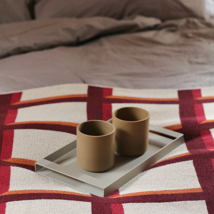 Modern Grid Throw Blanket in Burgundy and Red and Orange with Coffee Cups in Bed