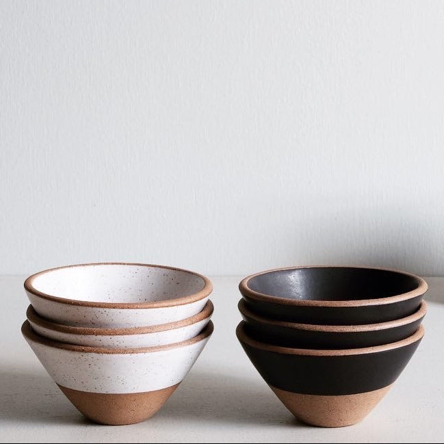 Set of ceramic bowls and cups on a light gray background