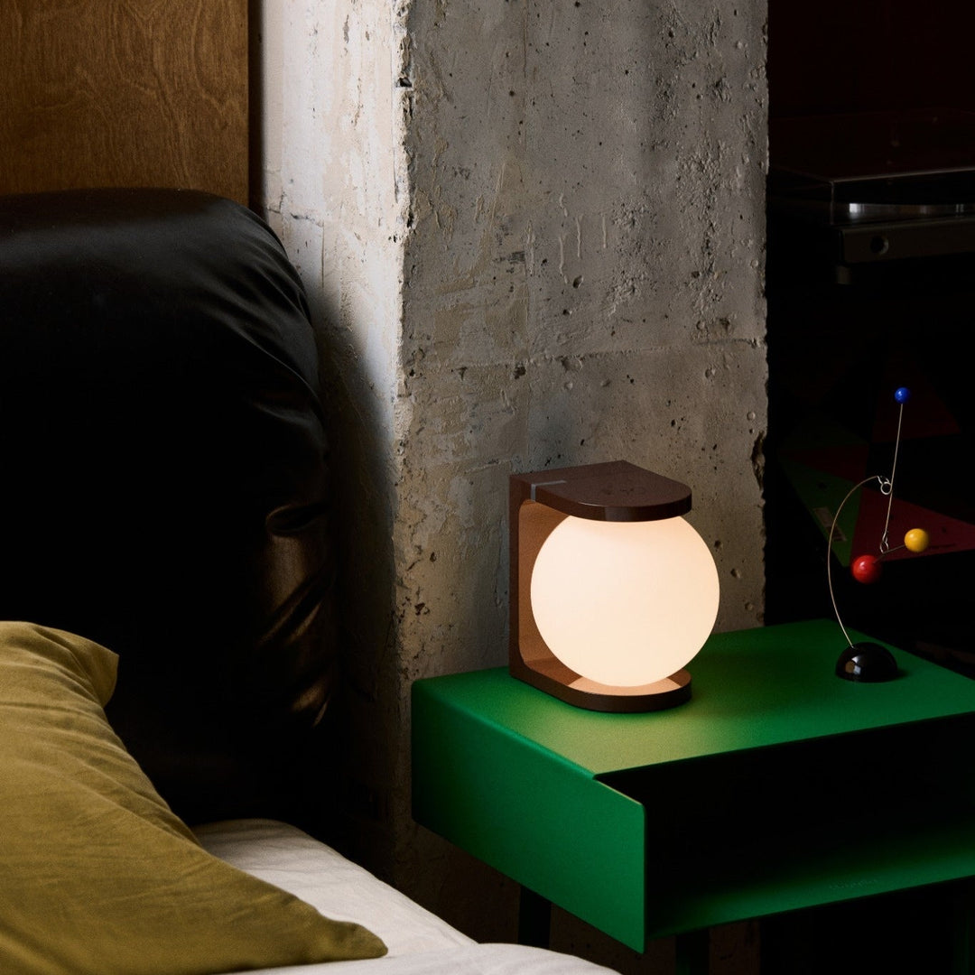 Bedroom scene with a green nightstand and glowing lamp.
