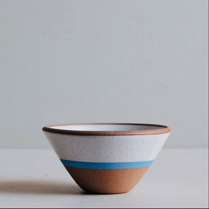 Ceramic bowl with brown base and white top on a light gray background