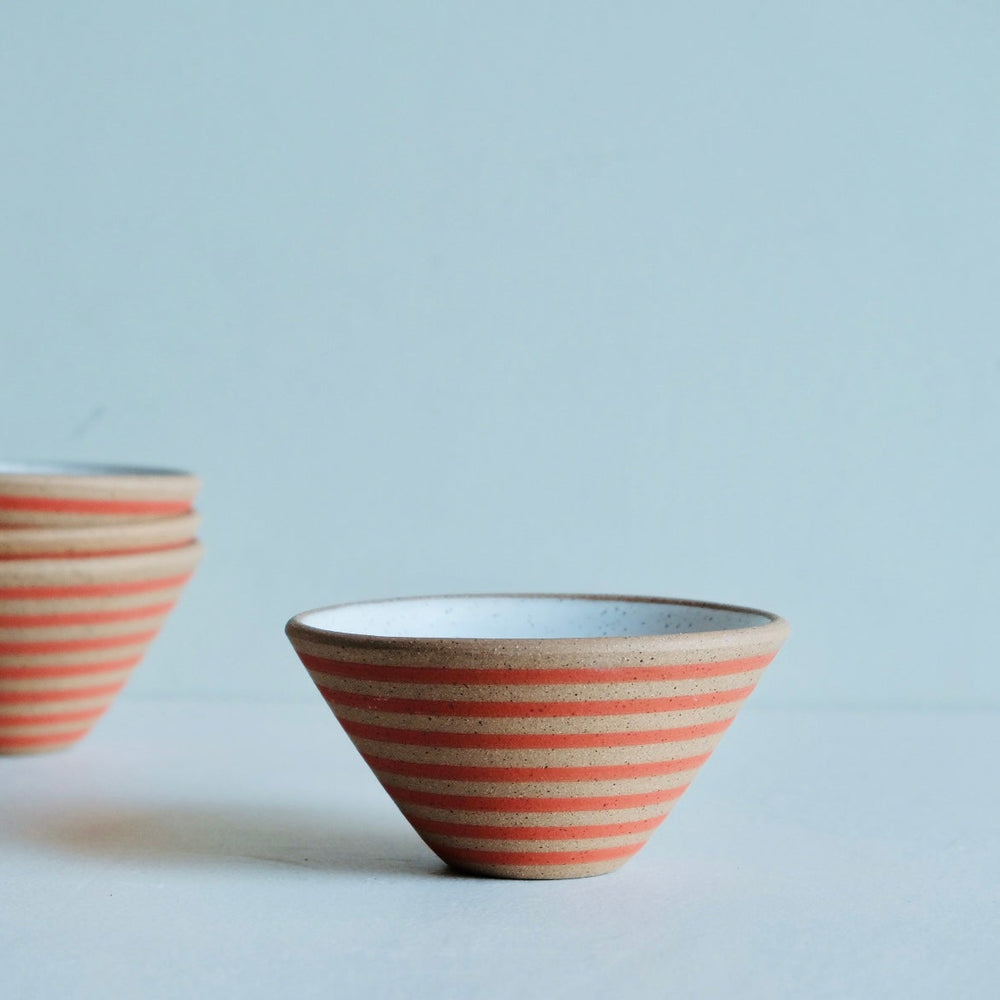 Two ceramic bowls with red and white stripes on a light gray background