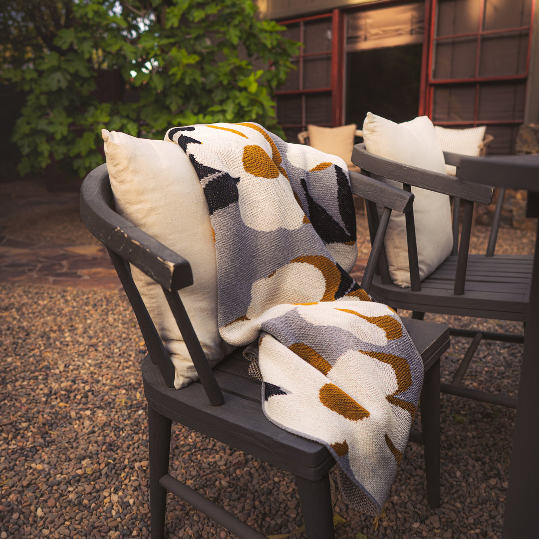 Grey and Gold Flower Throw on patio