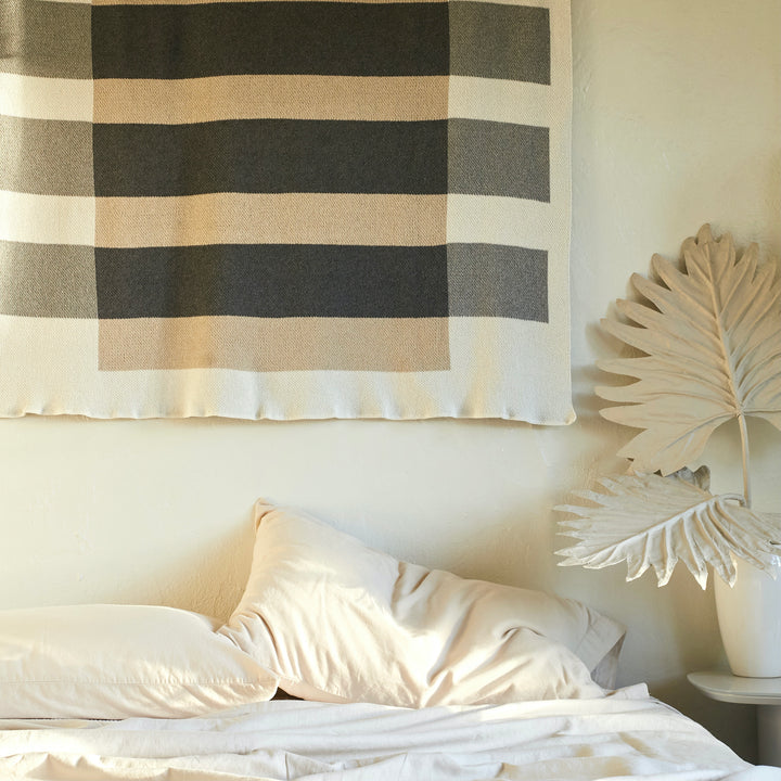 Neutral Throw Hanging on Wall Above Bed